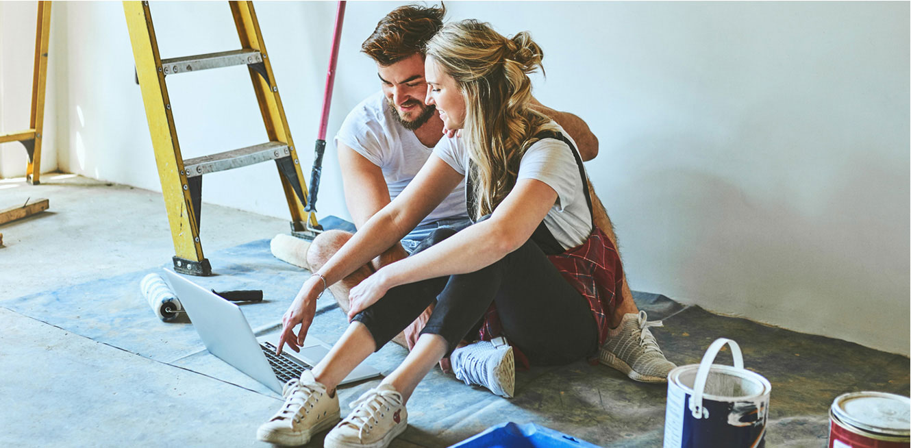 Young couple taking a break from painting their home.